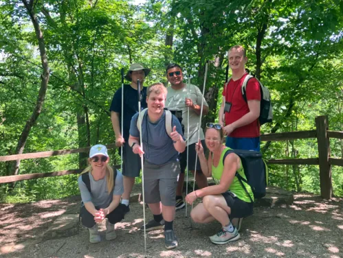 A group of LEAP students stand together and smile for a group photo during a hike