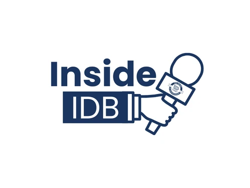 A white background with navy blue text that reads "Inside IDB" with a hand holding a microphone