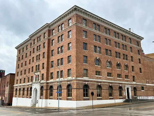 A large historic brick building with six floors on the corner of two streets