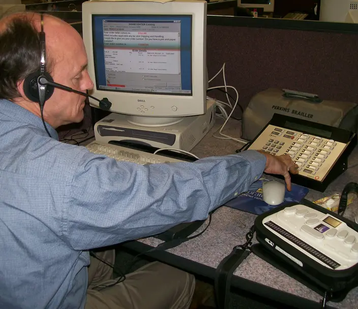 Man working taking an order over the phone with braille display