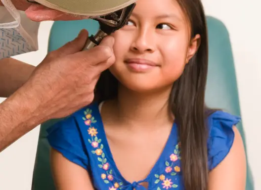 An ophthalmologist (eye doctor) examining a patient's eye with an ophthalmoscope