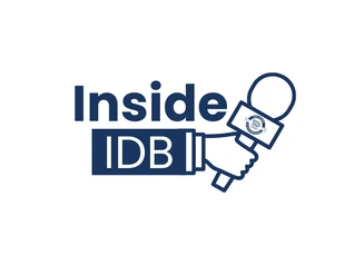 A white background with navy blue text that reads "Inside IDB" with a hand holding a microphone