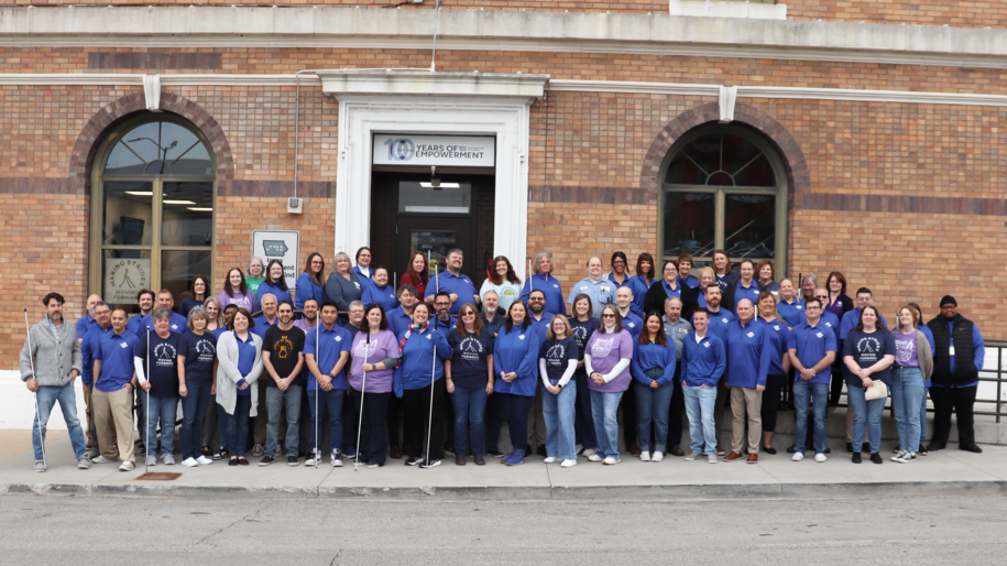 Staff standing in 3 rows in front of the north side of the building.